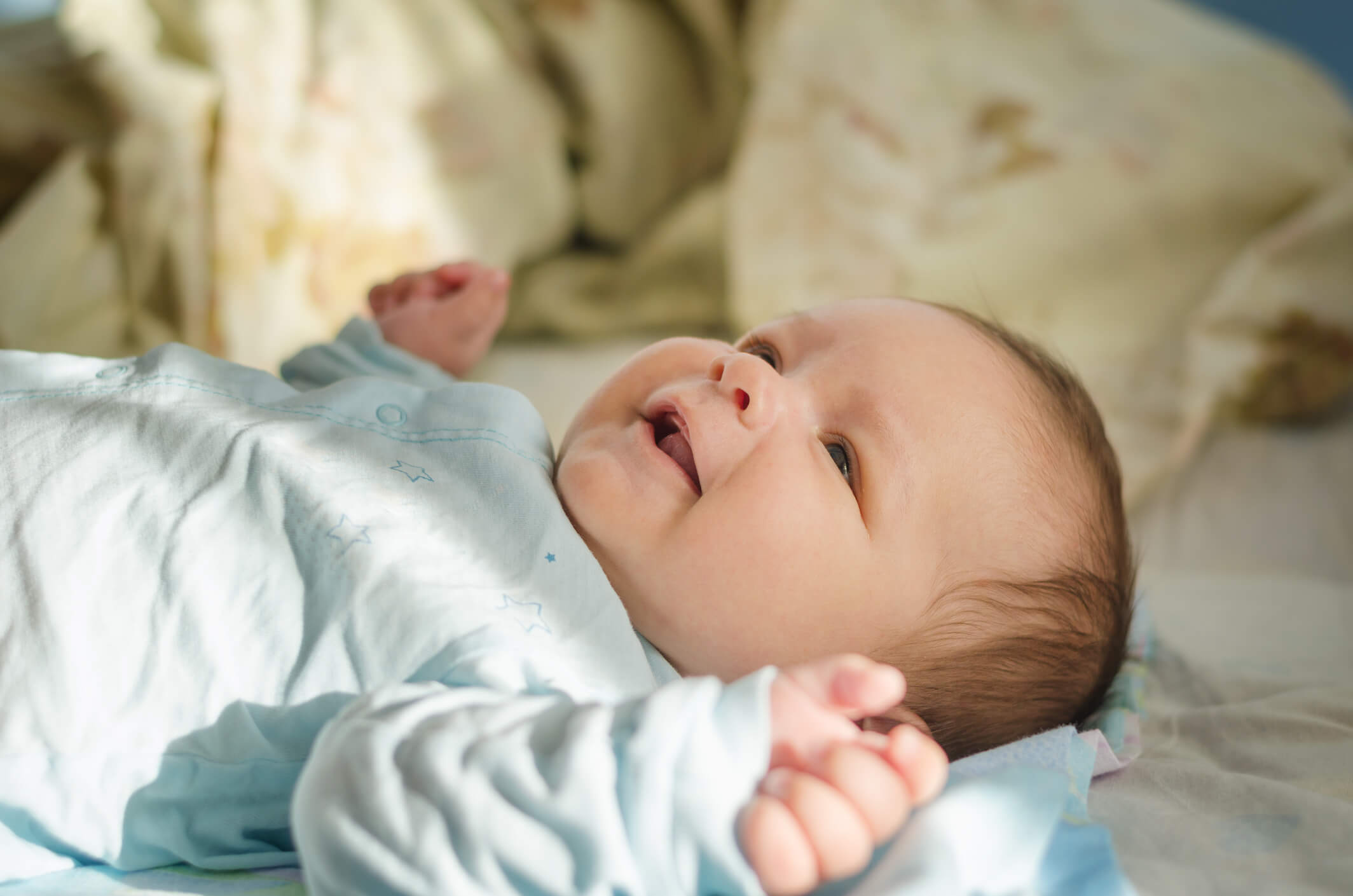 Pequeño en la cama sonriendo