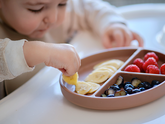 Un niño disfrutando de frutas frescas.