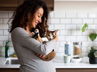 Mujer embarazada sosteniendo a su gatito